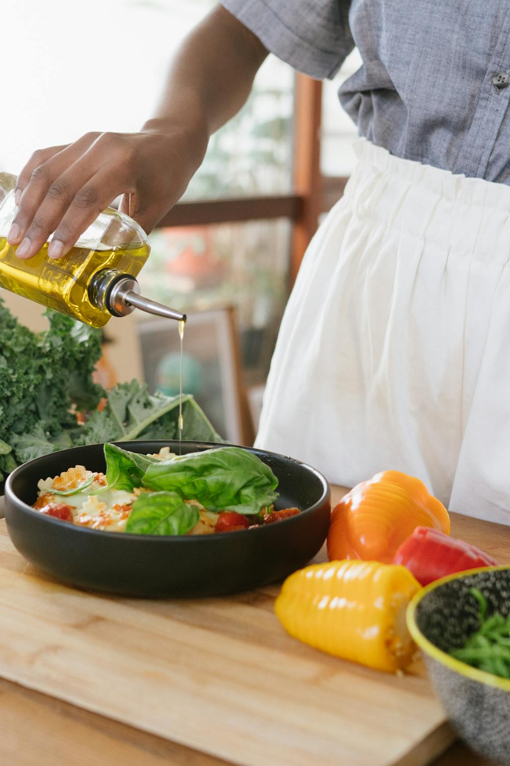 Pouring olive oil on pasta